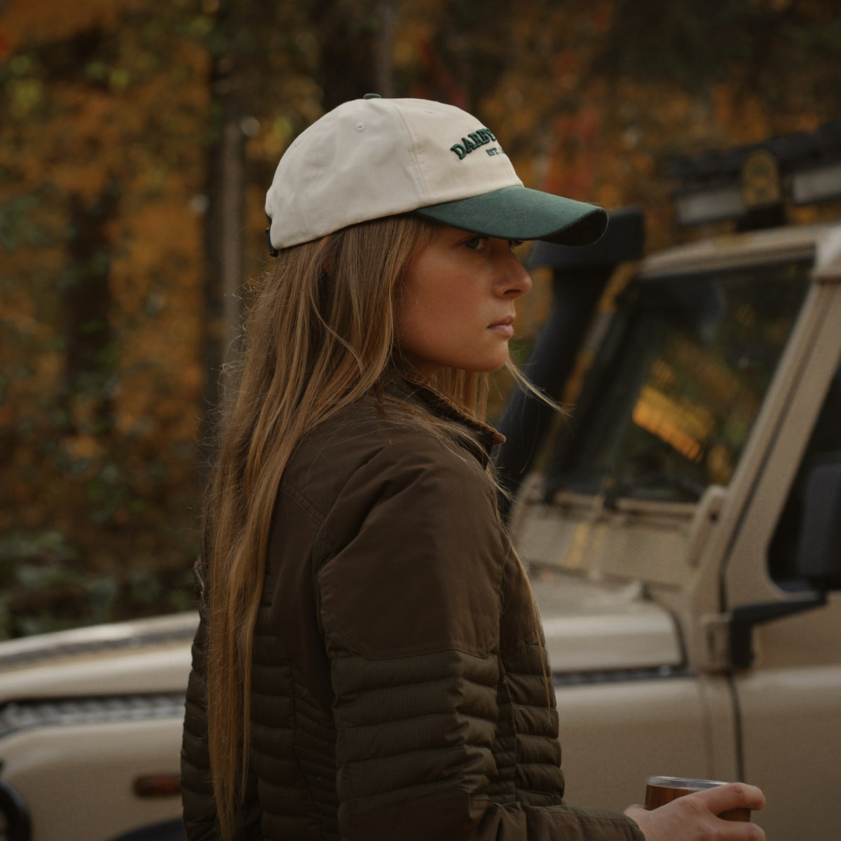 Side view of the Canvas Cap worn with long hair beside a vintage truck.